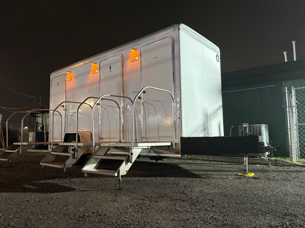 Three-stall luxury restroom trailer lit up at night